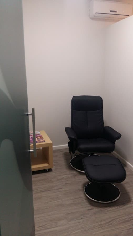 Consultório com cadeira e mesa.